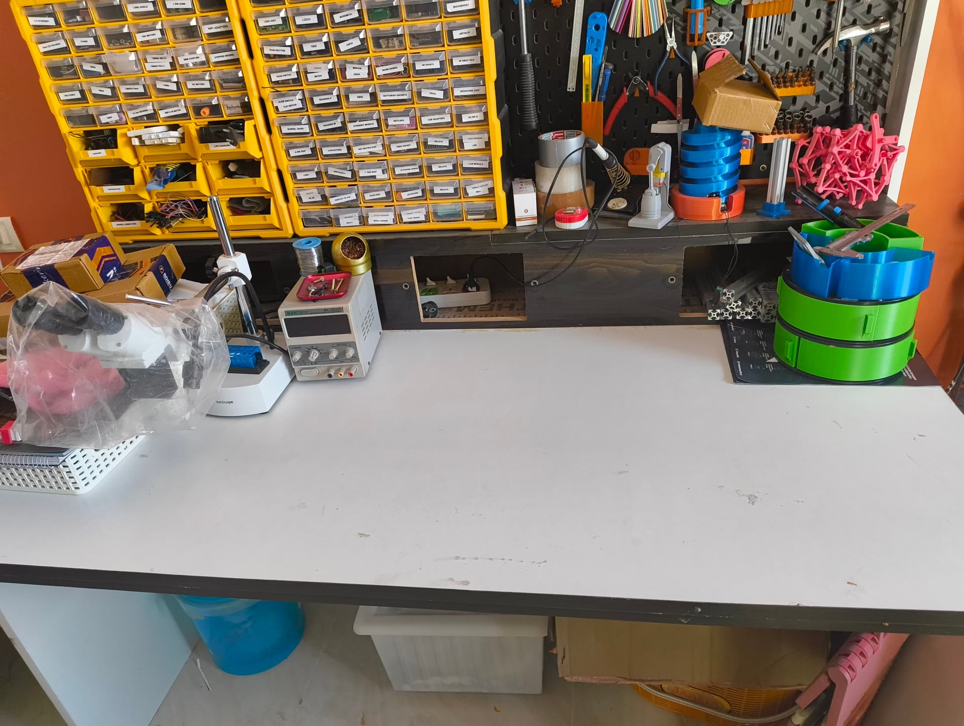 A cleared electronics bench beneath component drawers and a wall of hand tools