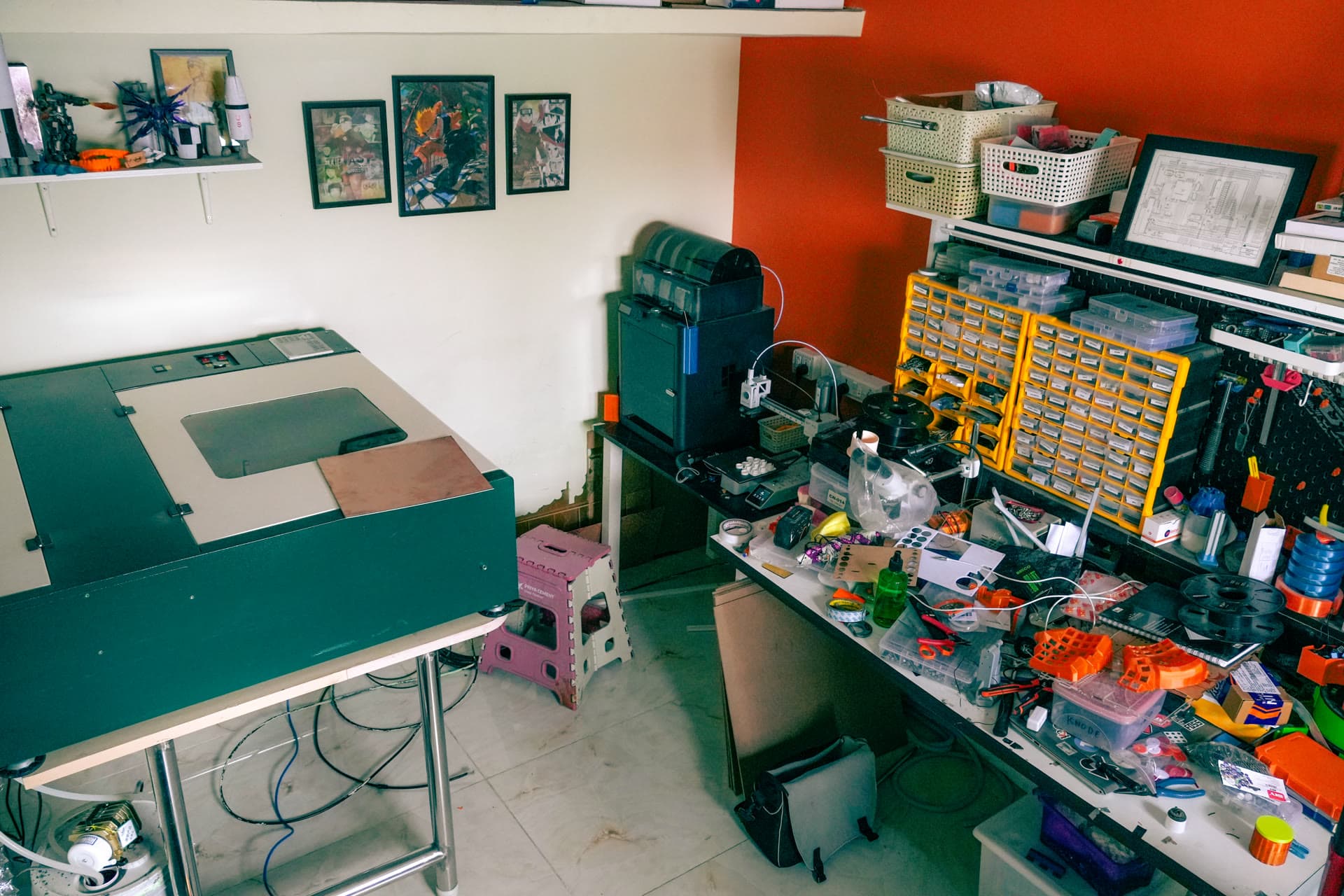 The new laser cutter beside a crowded workbench in the workshop